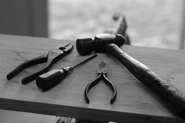 Four hand tools laid out on a board, ready for an appliance service call