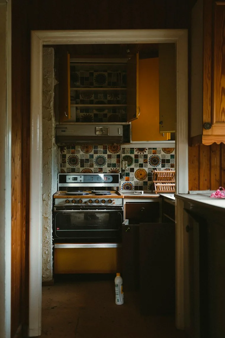 Home kitchen with a built-in oven and stovetop set into wood cabinets