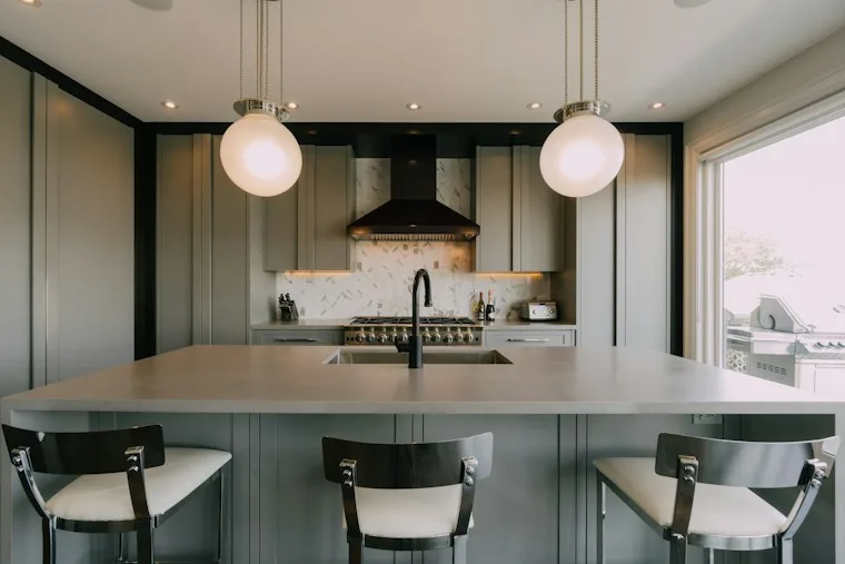 Kitchen with a center island, three chairs and built-in appliances