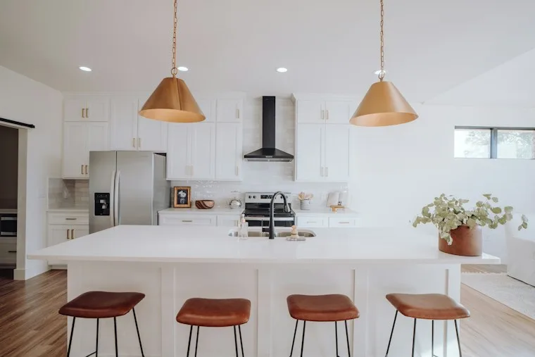 Kitchen with a center island, three stools and built-in appliances