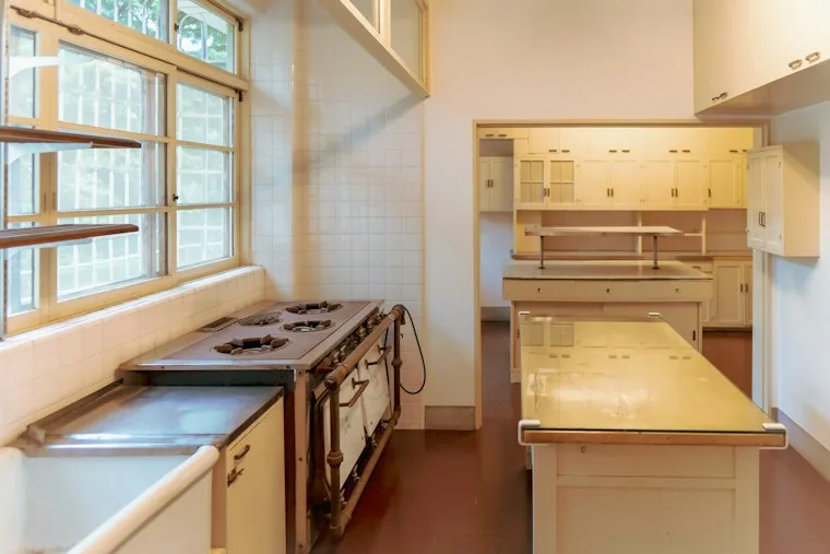 Kitchen with a stove top oven next to a bright window