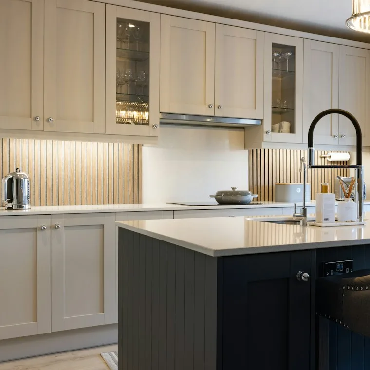 Kitchen with white cabinets and a dark island in a family home