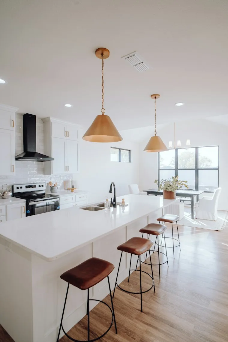 Large kitchen with a center island, bar stools and built-in appliances