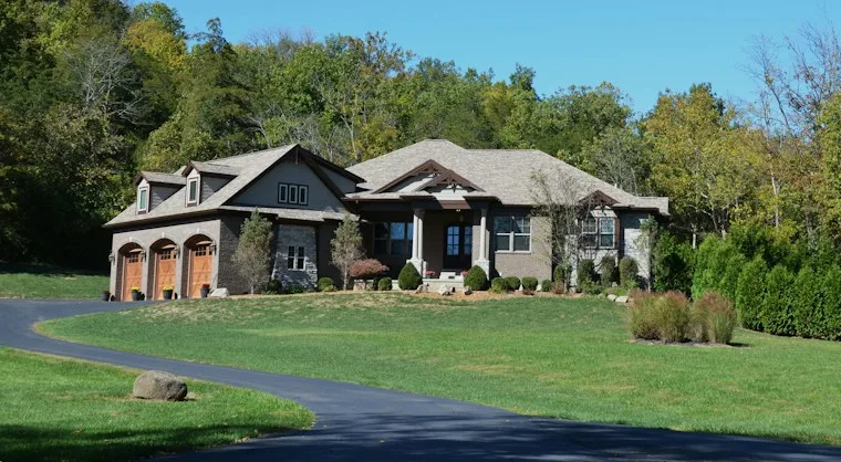 Large modern two-story home with a garage and green lawn in a newer neighborhood