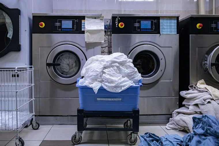 Laundry room with a washing machine and a basket of clothes