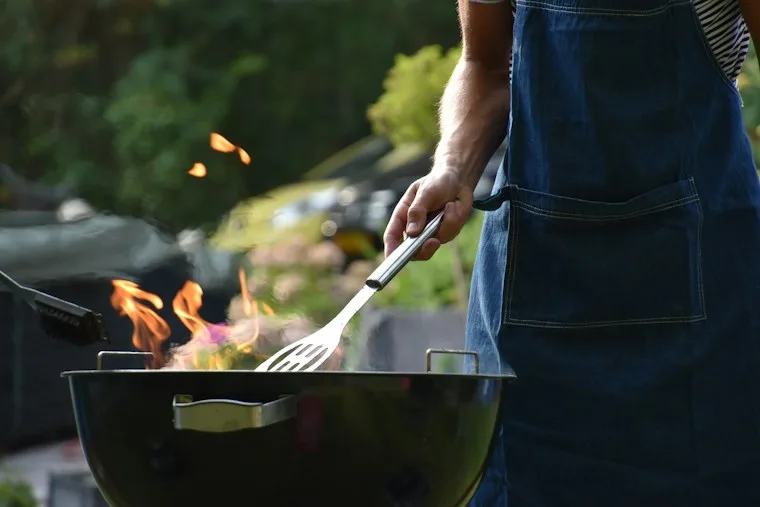 Man grilling food outdoors on a built-in grill