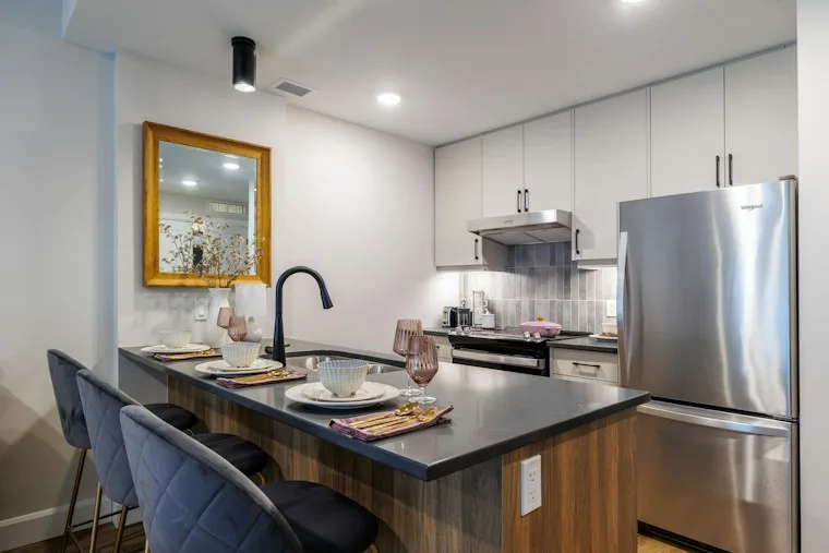 Modern kitchen island with bar stools and a full set of built-in appliances