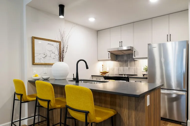 Modern kitchen with a large island, yellow bar stools and new appliances