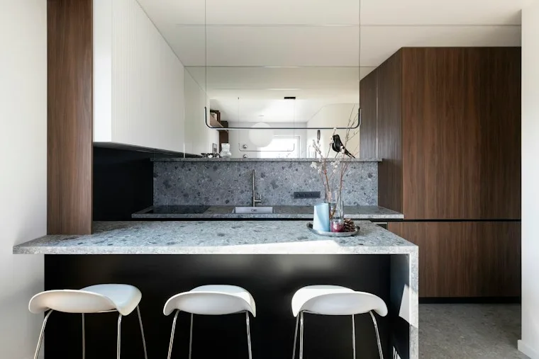 Modern kitchen with dark wood cabinets and speckled stone counters