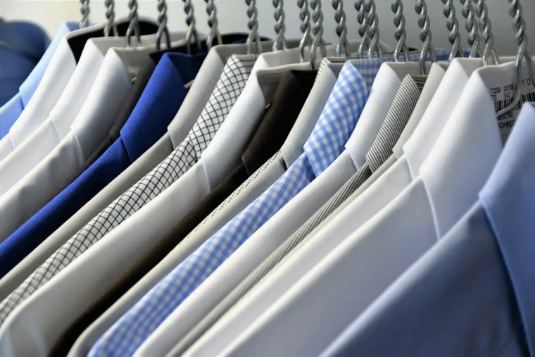 Row of colorful dress shirts hanging on hangers