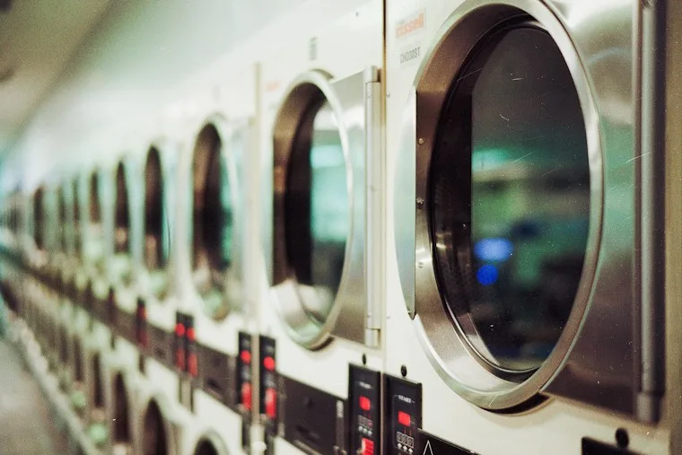 Row of front-load washing machines in a shared laundry space