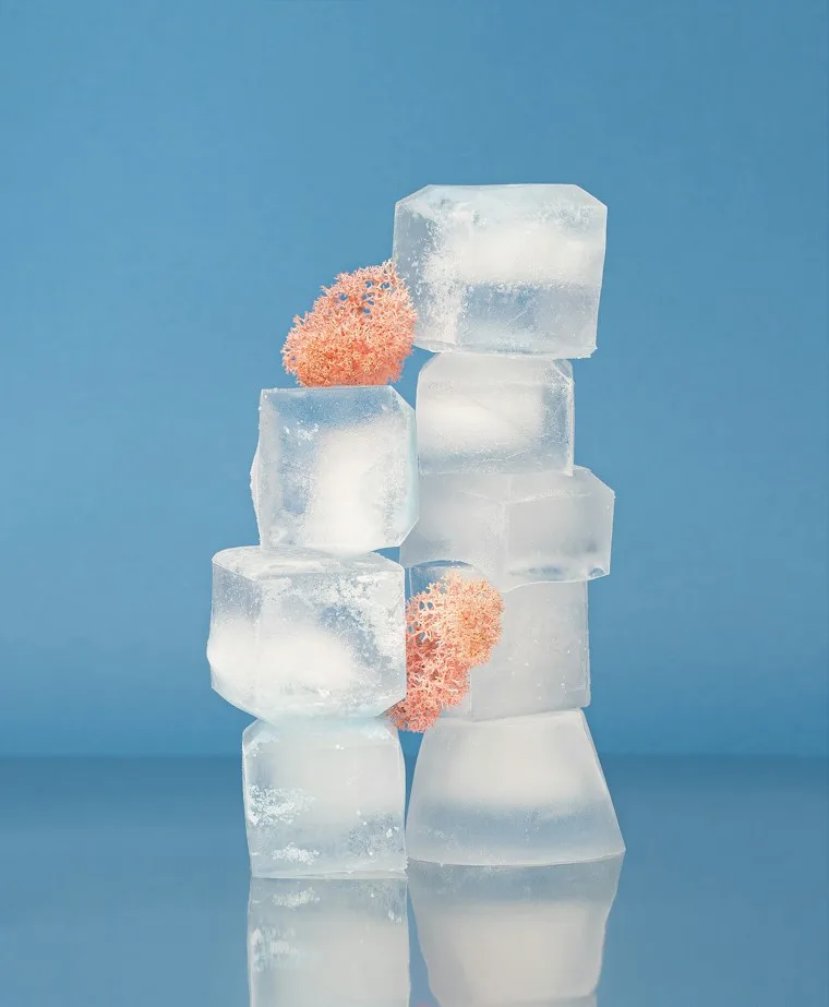 Stack of clear ice cubes on a light background