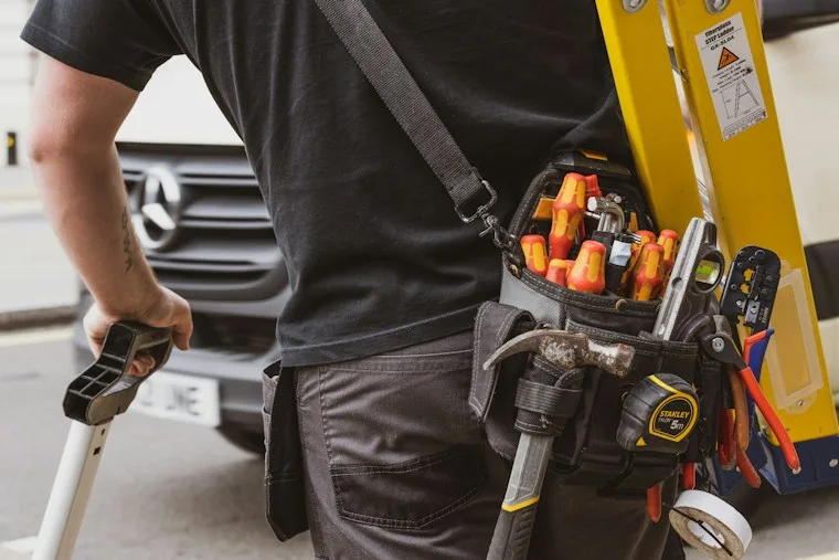 Technician holding a power tool, ready to start a repair job