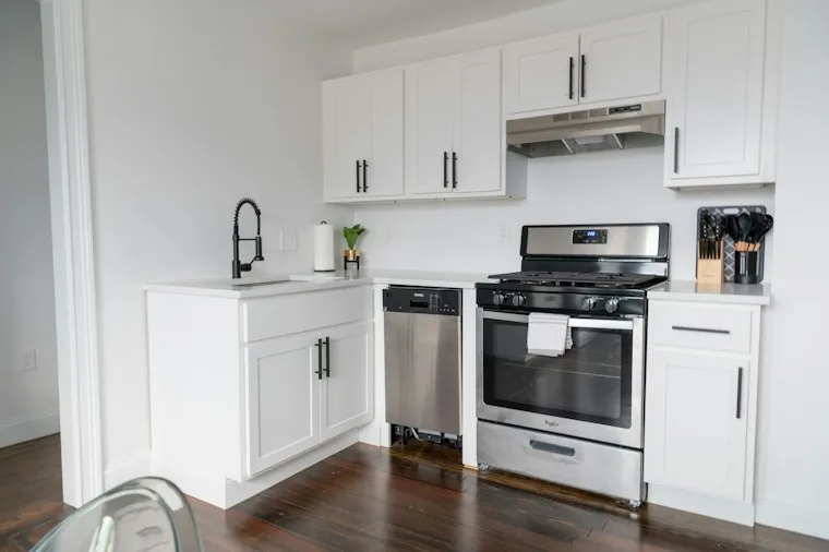 White kitchen cabinets with a built-in white microwave oven
