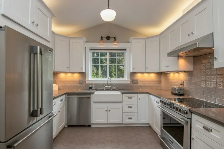 White kitchen cabinets with a white pendant lamp in a bright home
