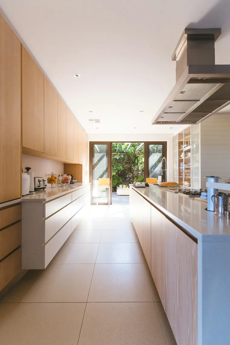 White kitchen island and cabinets next to a glass door in a family home