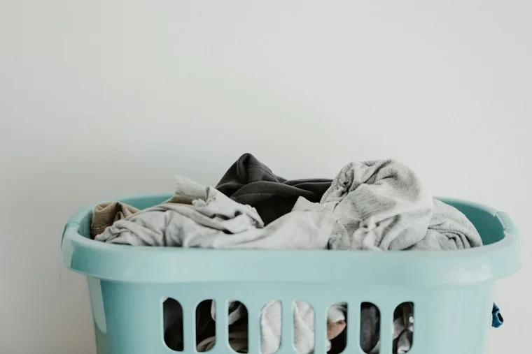 White laundry in a blue plastic laundry basket